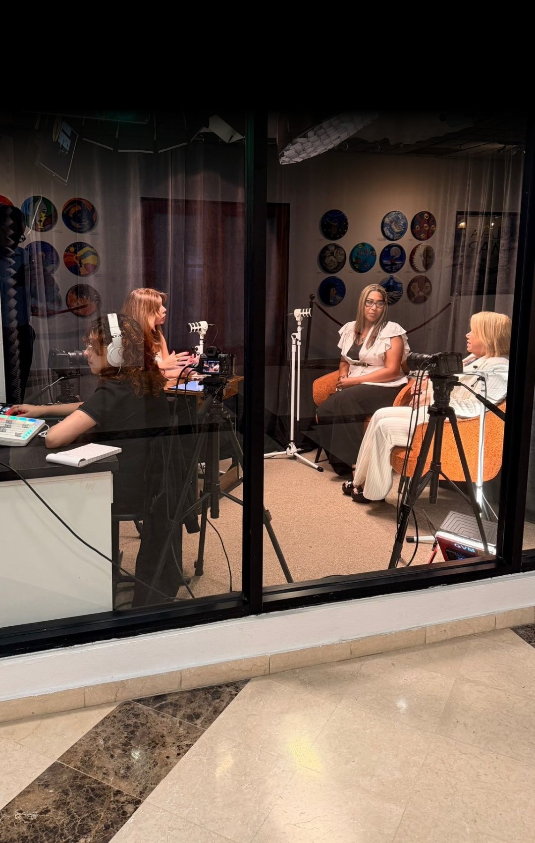 Estudio de Link Studios visto desde el cristal con letrero de neón ON AIR mientras se graba una entrevista